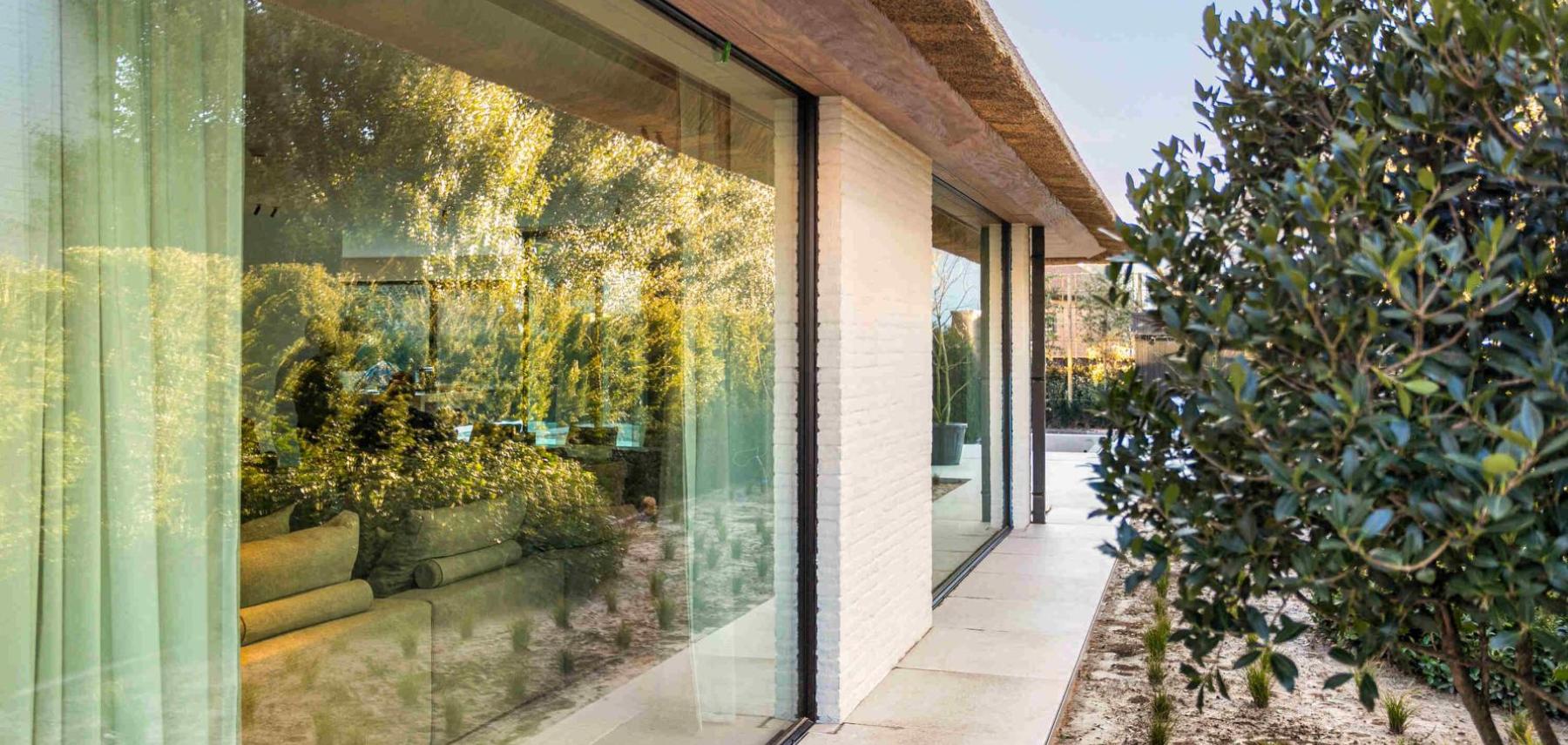 Groot aluminium raam in het zwart bij een moderne warme woning