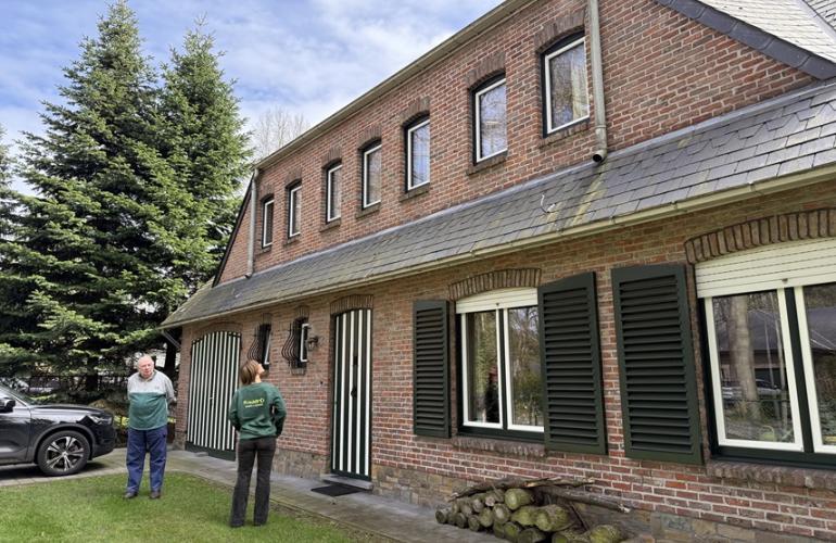 Woning met groene en witte pvc-ramen met luiken