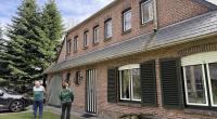 Woning met groene en witte pvc-ramen met luiken
