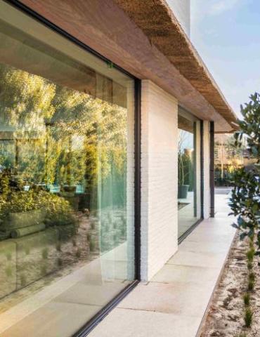 Groot aluminium raam in het zwart bij een moderne warme woning