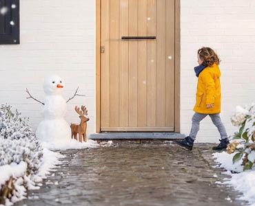 voordeur met sneeuw en een sneeuwpop