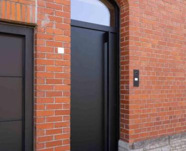 Moderne zwarte aluminium voordeur in gerenoveerde woning